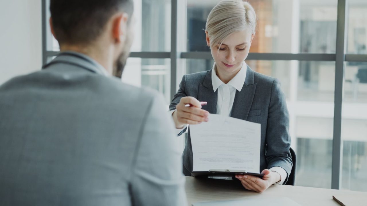 Hiring team reviewing background check paperwork and timelines in an office